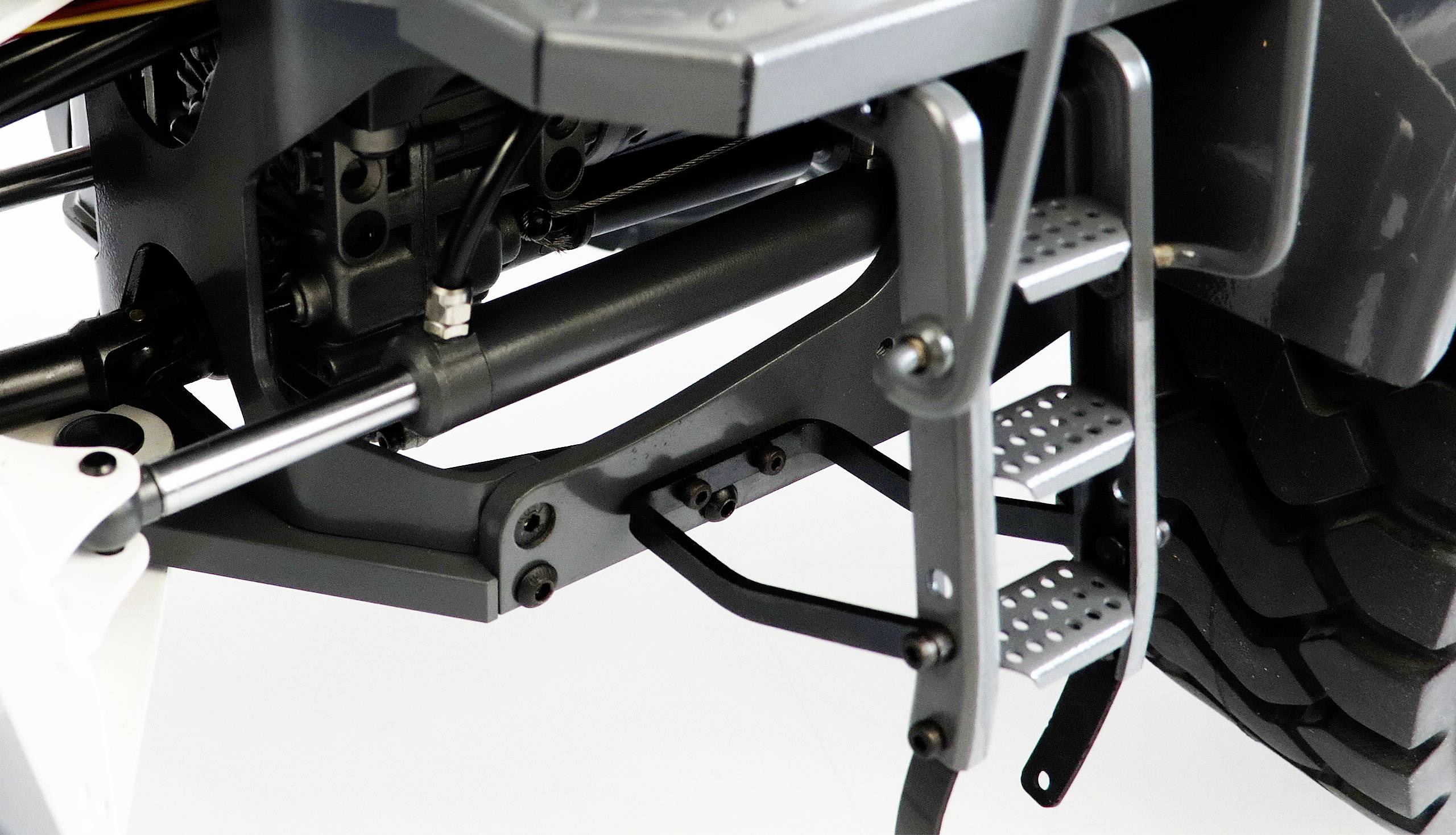 Zbliżenie podwozia pojazdu z dokładnym widokiem zawieszenia i stopni wejściowych.