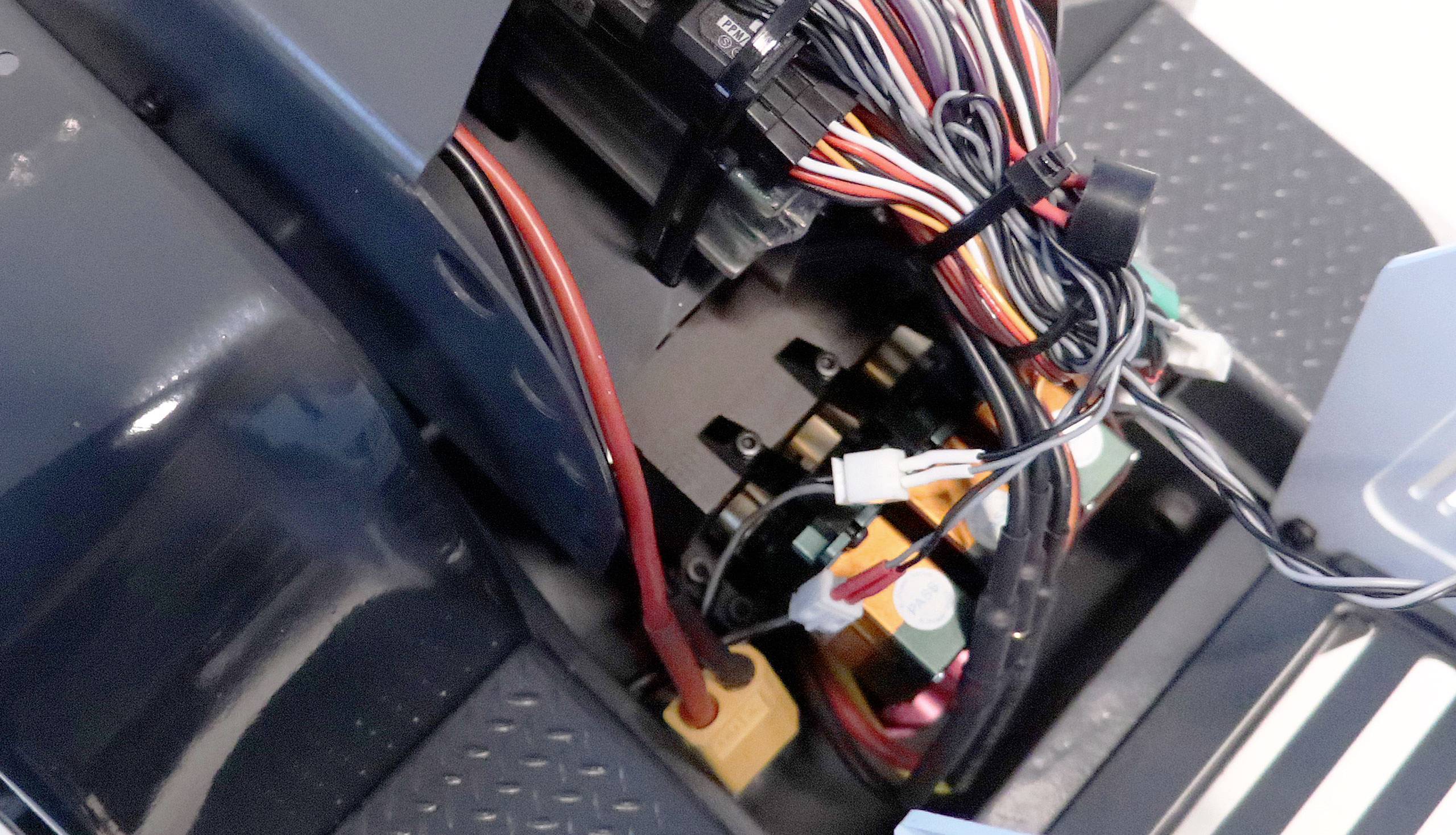 Otwarta maszynownia ukazuje liczne kolorowe kable i elementy elektryczne połączone ze sobą.