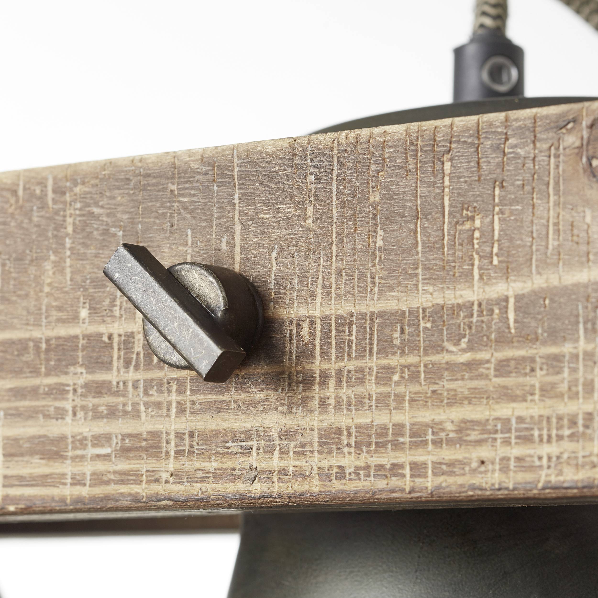 Struktura drewna z metalowym okukiem. Okucie jest ciemne i kontrastuje z rustykalnym, jasnym drewnem, które nosi ślady użytkowania.