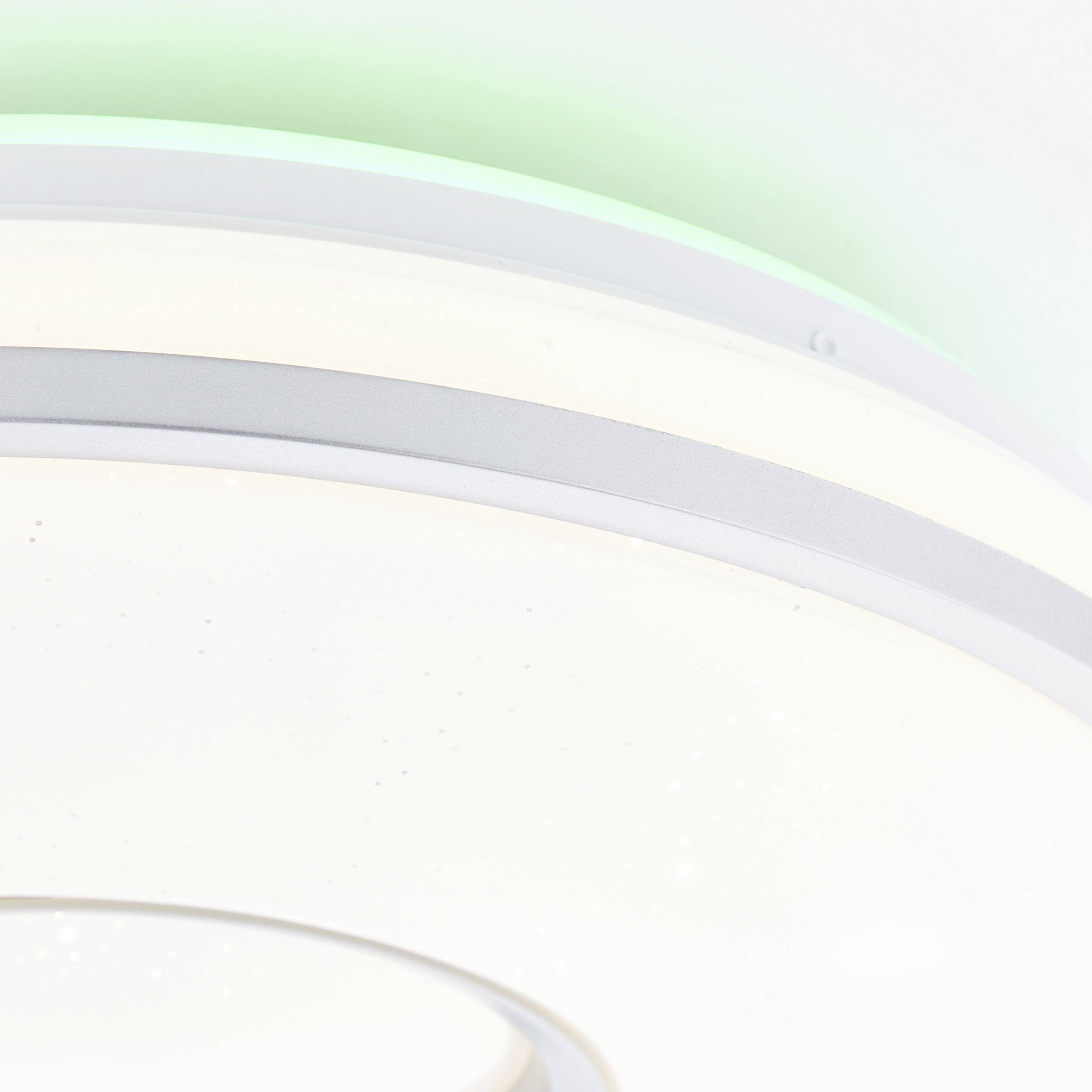 Biała lampa sufitowa w zbliżeniu z zielonym efektem świetlnym na krawędzi. Minimalistyczny design, czyste linie, nowoczesny styl.