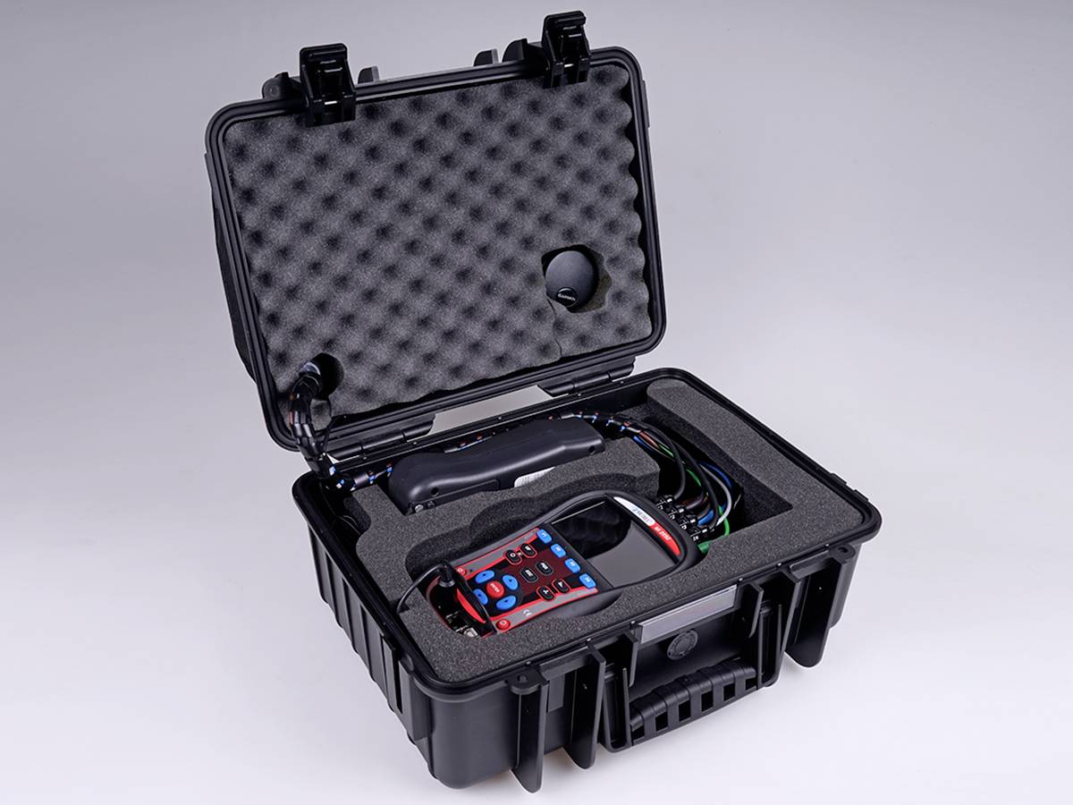 Otwarty czarny hermetyczny kufer ochronny z wkładką piankową, zawierający elektroniczny przyrząd pomiarowy z podłączeniami kablowymi.