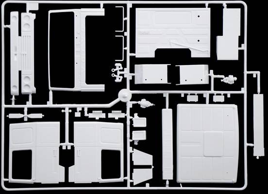 Zestaw plastikowych elementów modelarskich leży na czarnym tle, gotowy do złożenia. Części o różnych kształtach.