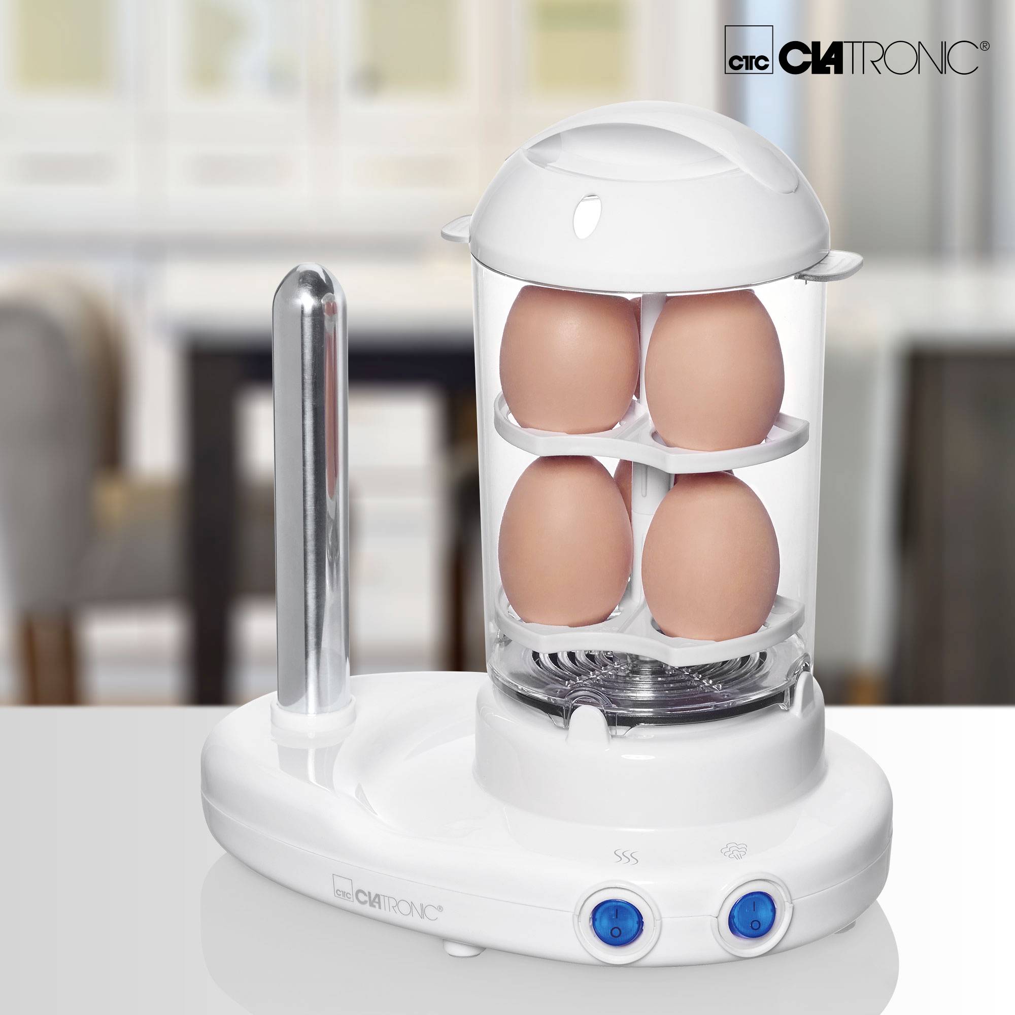 Urządzenie kuchenne do gotowania jajek z czterema jajkami pod przezroczystą kopułą na blacie kuchennym. Marka widoczna w prawym górnym rogu: 'Clatronic'.