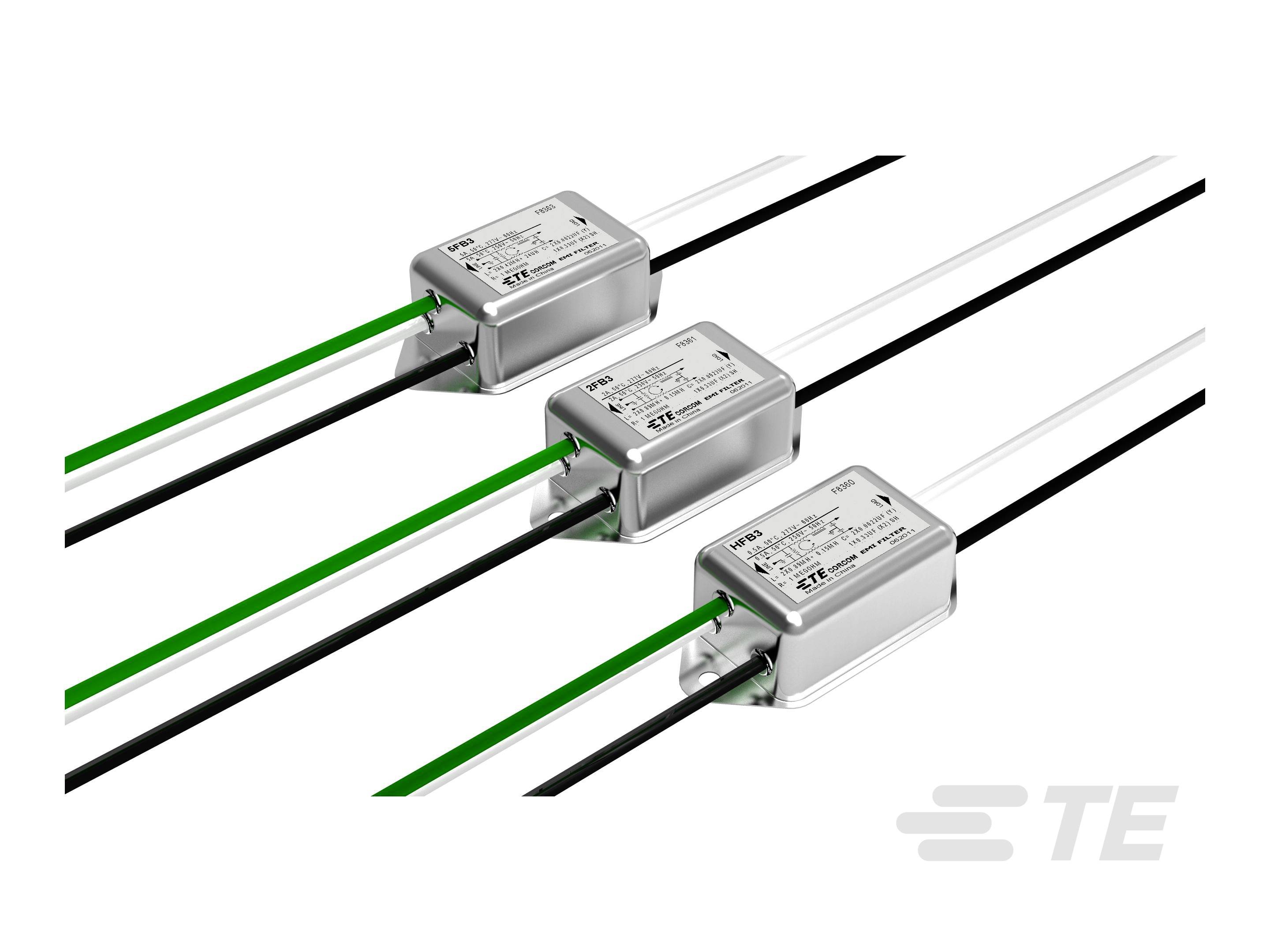 Trzy elektroniczne filtry z zielonymi, czarnymi i białymi przewodami na białym tle. Produkty firmy TE Connectivity.