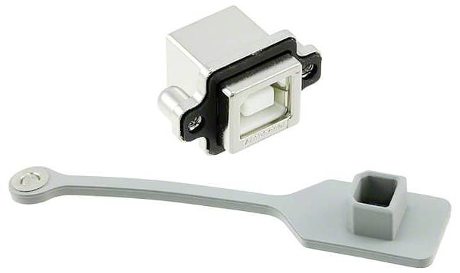 Port USB Type-B z pokrywą przeciwkurzową. Port jest prostokątny z metalową ramką. Szara silikonowa pokrywa przeciwkurzowa posiada uchwyt.