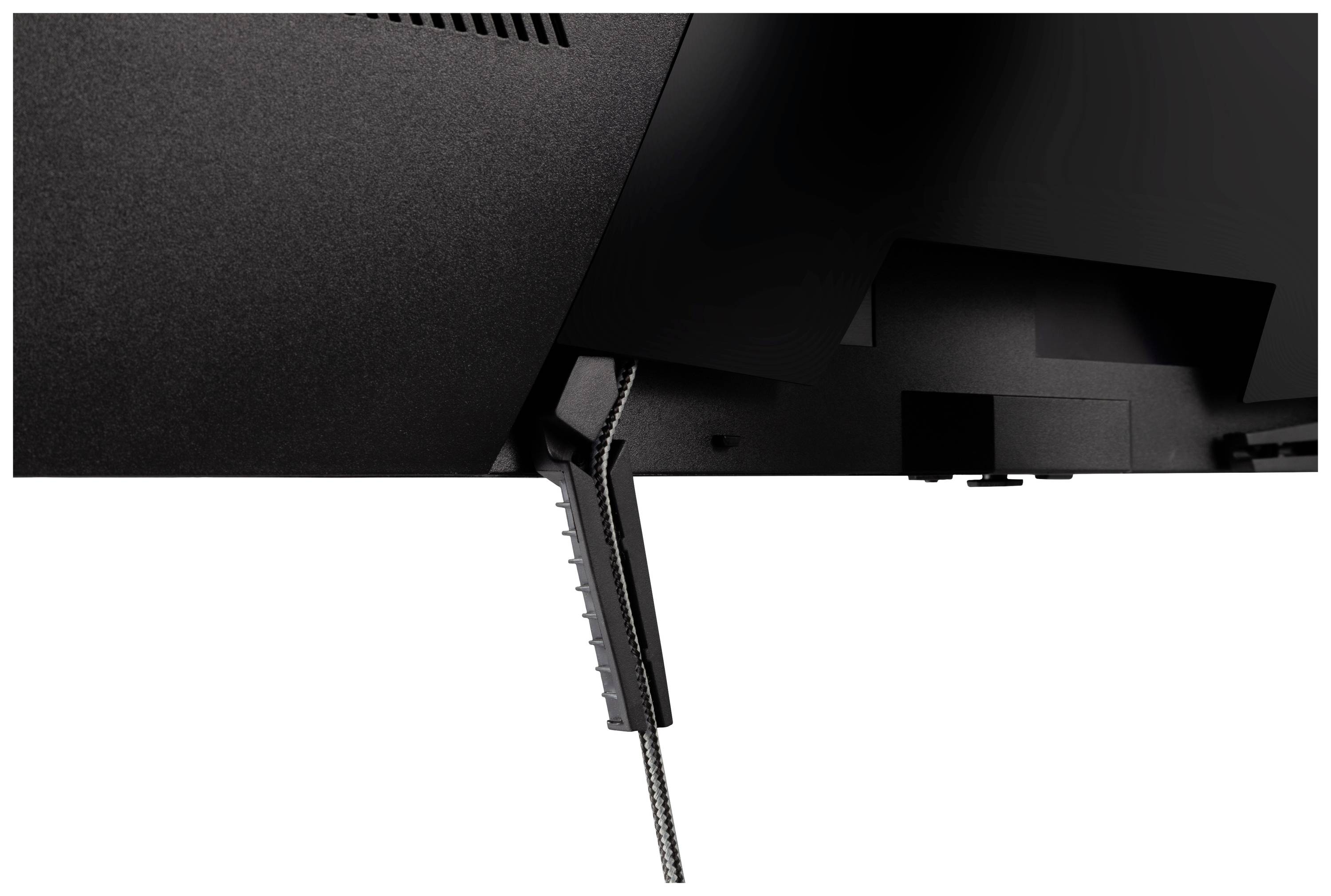 Widok z tyłu urządzenia elektrycznego z widocznym przewodem zasilającym i szczelинами wentylacyjnymi w obudowie.