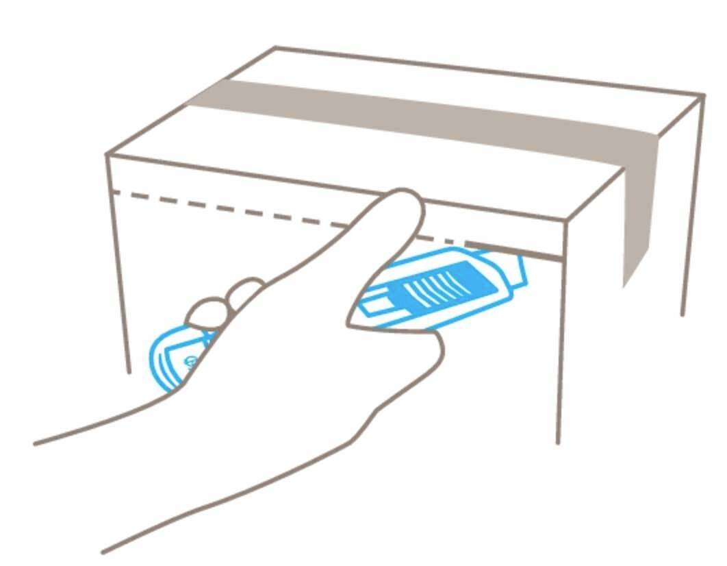 Jedna ręka wyjmuje małą paczkę z otwartego kartonu.