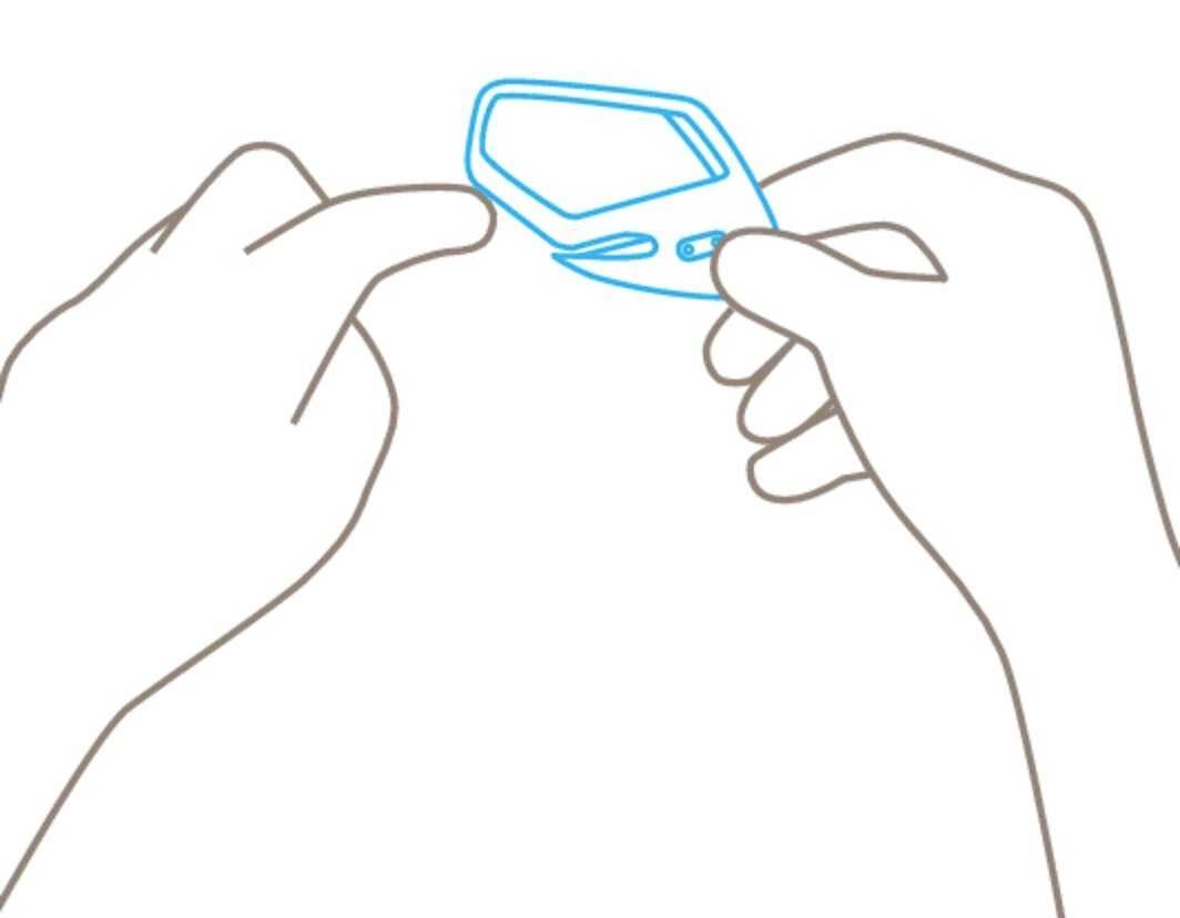 Dwie ręce trzymają glukometr, palec jest przygotowywany do badania.