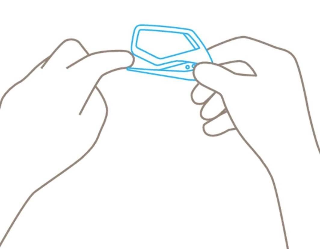 Osoba trzyma okulary między palcami obu dłoni.