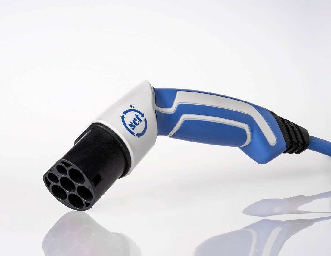 Wtyczka ładowania do pojazdów elektrycznych na białym tle, z niebieskim uchwytem i wieloma otworami przyłączeniowymi.