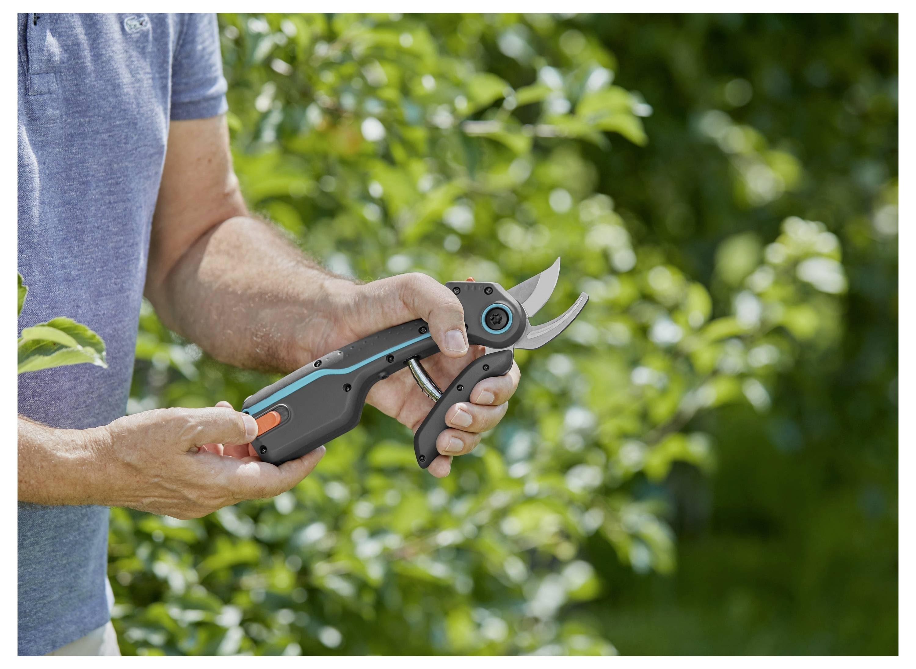 Osoba trzymająca parę nożyc ogrodowych w bujnym, zielonym ogrodzie, demonstrujący sposób ich użytkowania.