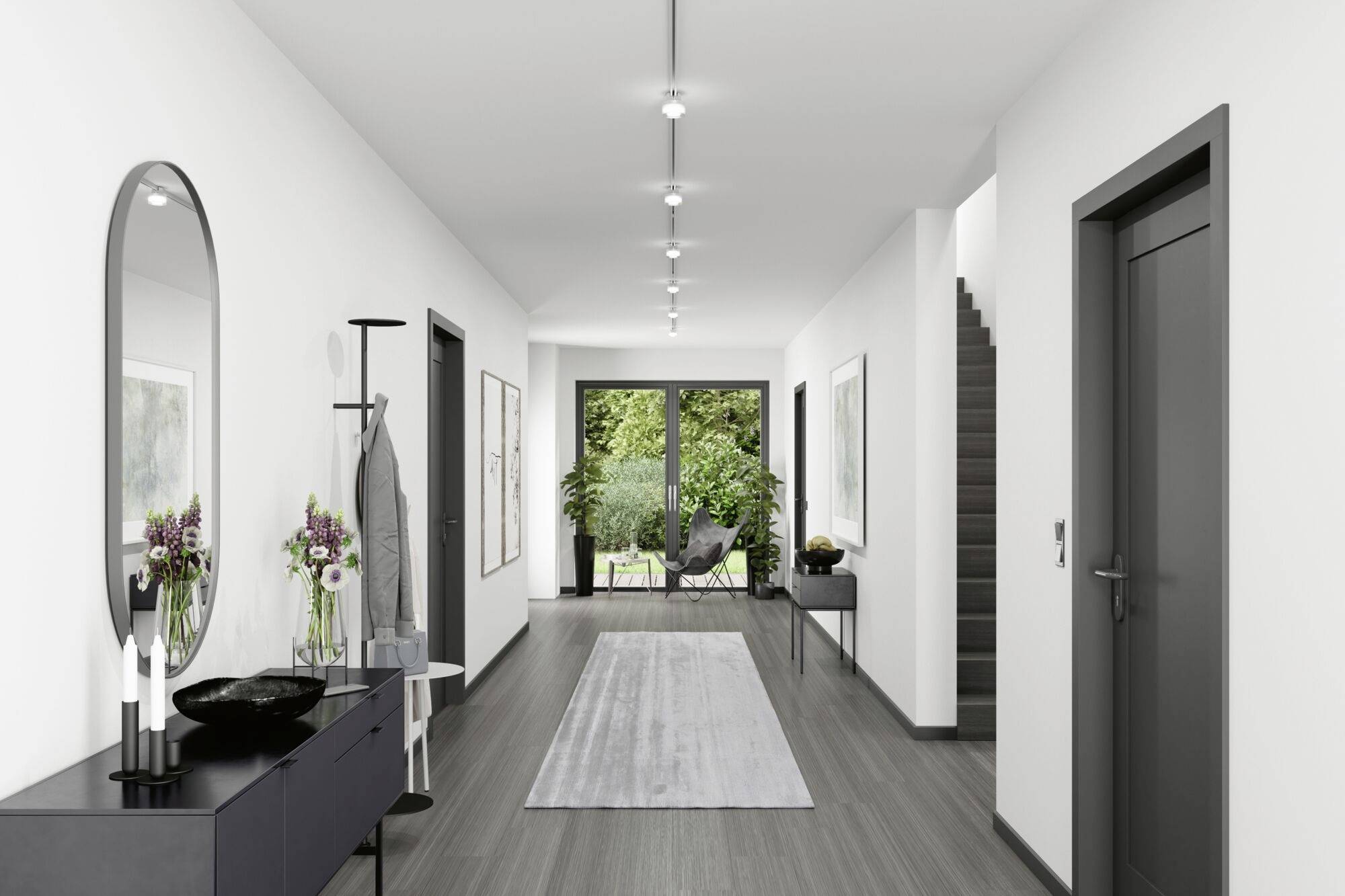 Długi, nowoczesny korytarz z szarą podłogą, ozdobiony roślinami i dziełami sztuki na ścianach. Na końcu korytarza drzwi prowadzą do ogrodu.