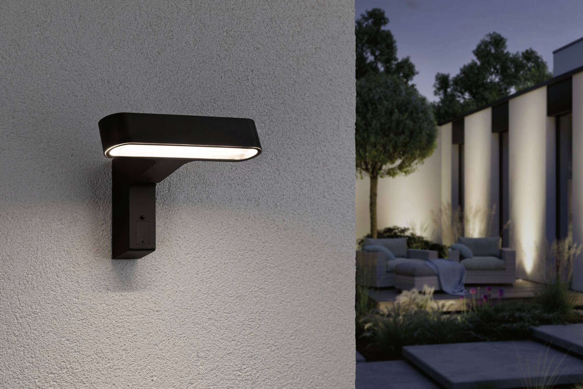 Lampa na ścianie zewnętrznej oświetla taras z meblami do siedzenia i roślinami w wieczorowej atmosferze.