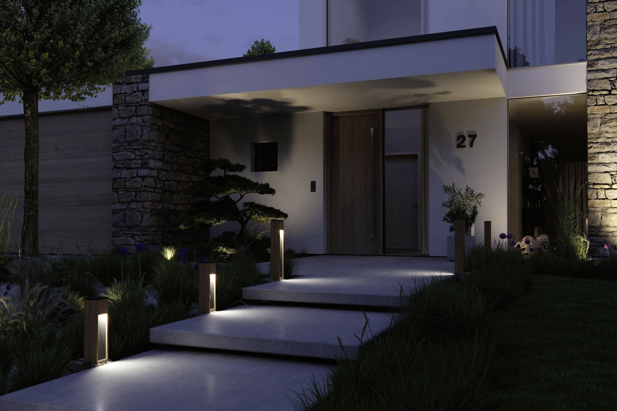 Wejście nowoczesnego domu o zmierzchu. Oświetlone stopnie prowadzą do drzwi wejściowych z numerem 27. Rośliny obramowują ścieżkę.