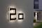 Numer domu '20', podświetlony na ścianie nowoczesnego domu, z rozmytym widokiem ogrodu i strefy wejściowej w tle.