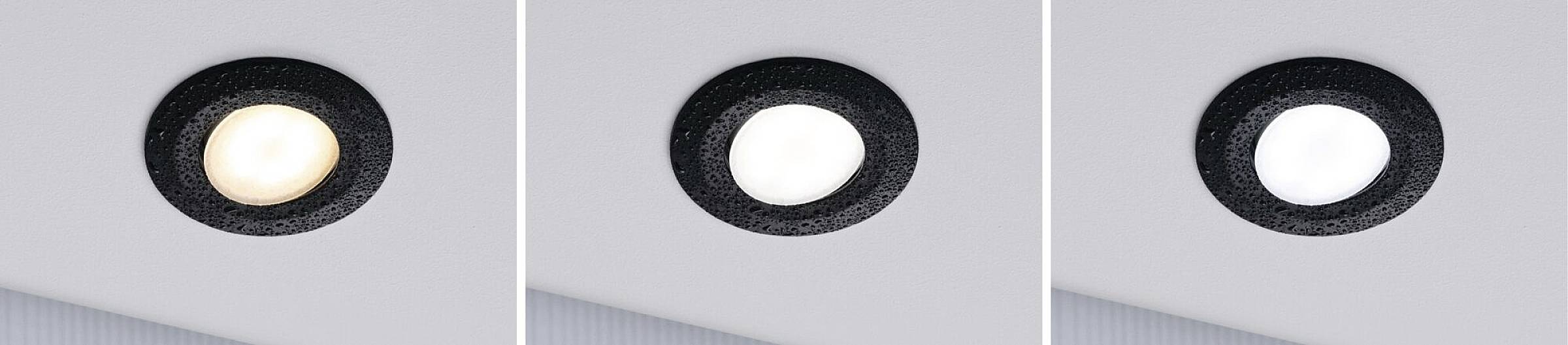 Trzy lampy LED w różnych odcieniach bieli: ciepłobiałe, neutralnobiałe i zimno białe, zamontowane w czarnej obudowie na suficie.