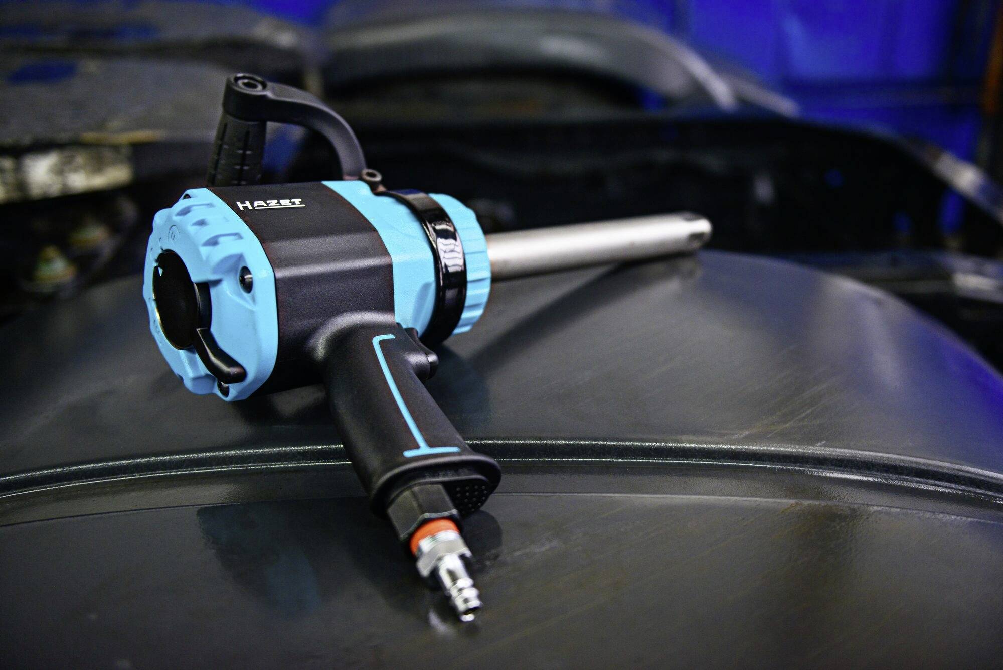 Czarno-niebieski dmuchawa gorącego powietrza leży na szarej metalowej powierzchni. Nadaje się do zastosowań przemysłowych.