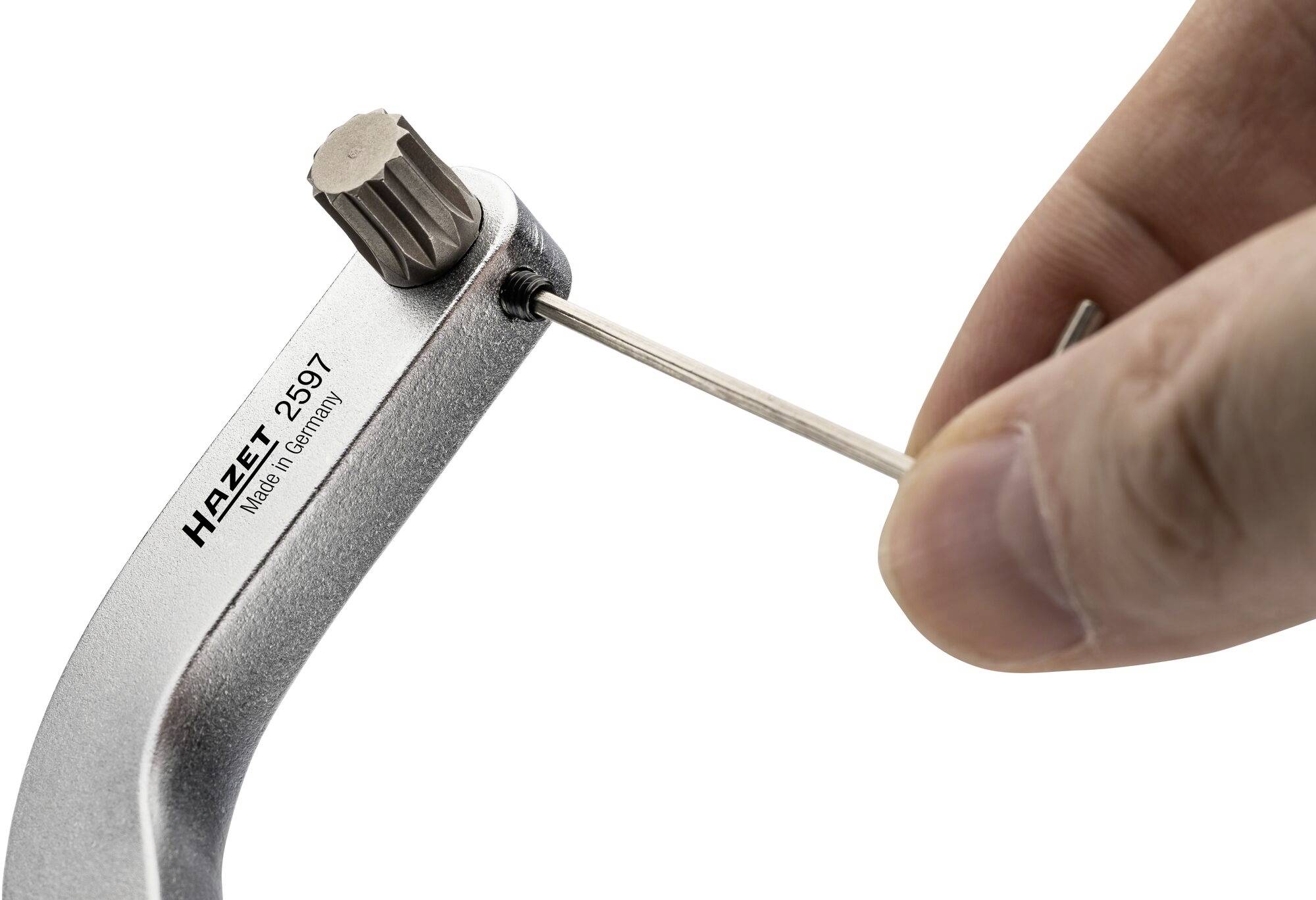 Jedna ręka trzyma klucz dynamometryczny Hazet, model 2597, i reguluje ustawienie małym rysikiem.