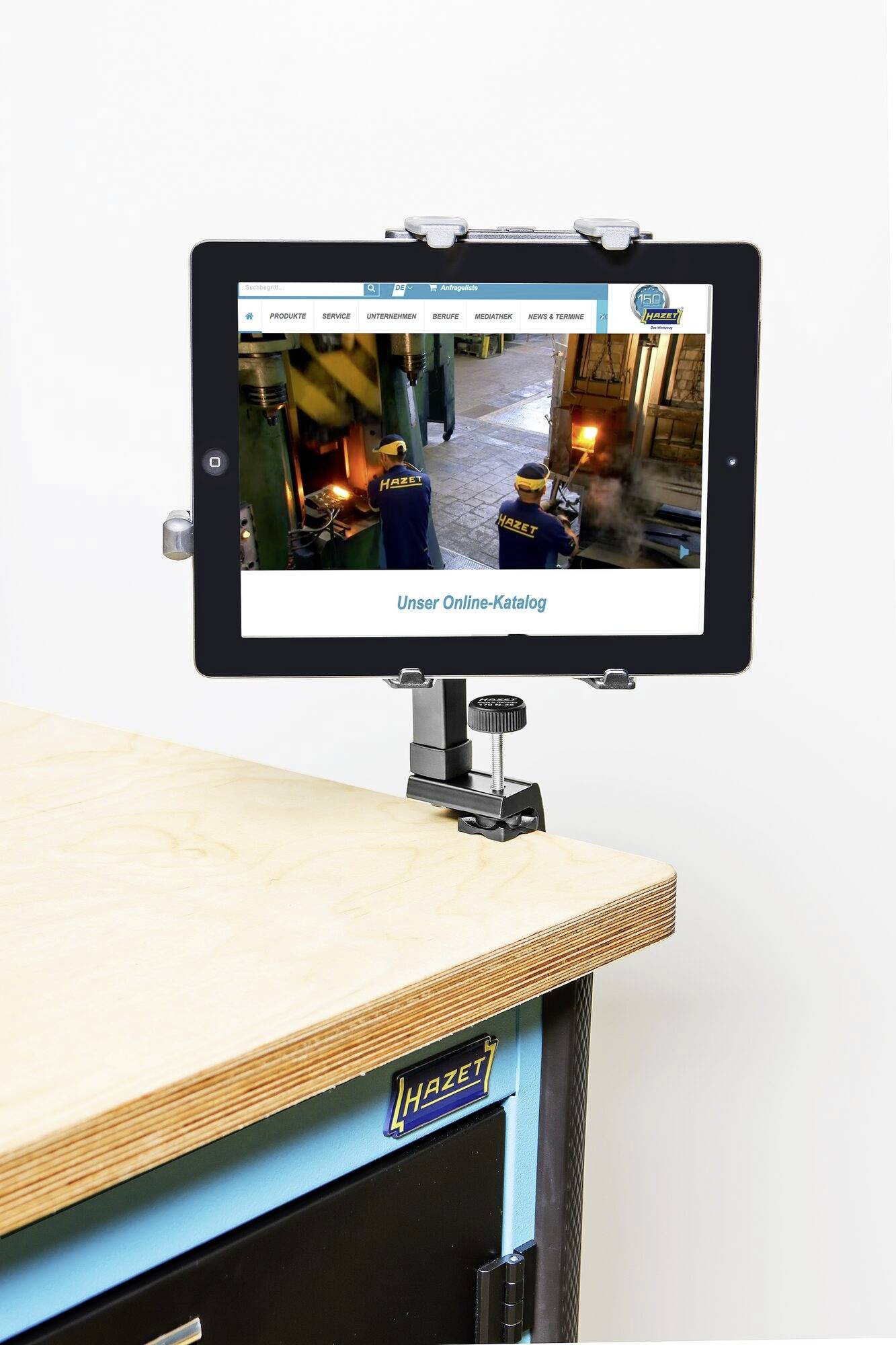 Tablet wyświetla stronę internetową firmy na drewnianym uchwycie warsztatowym, prezentując slogan "Nasz katalog online".