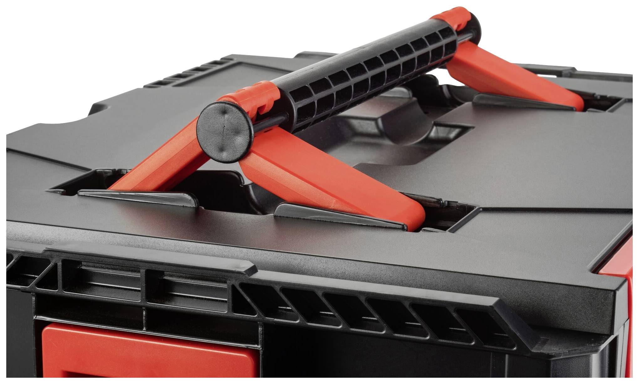 Skrzynka narzędziowa z czarną obudową i czerwonym uchwytem. Uchwyt jest zamocowany w podporowej strukturze.