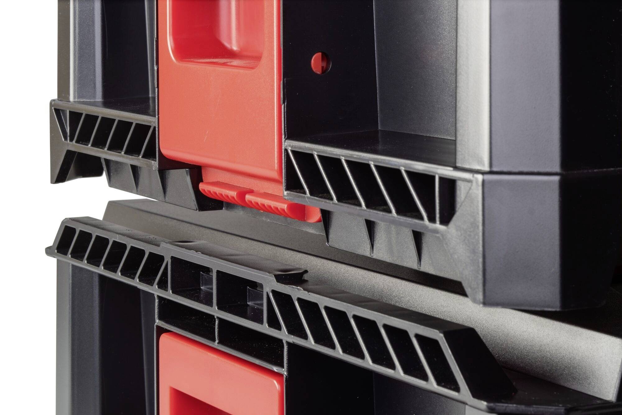 Zbliżenie na dwie czarne skrzynki narzędziowe ułożone jedna na drugiej z czerwonymi uchwytami.