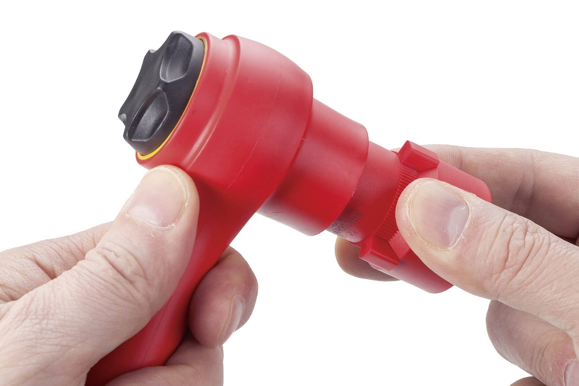 Jedna ręka trzyma czerwony, elektrycznie izolowany uchwyt narzędzia, podczas gdy druga ręka obsługuje obrotową blokadę.