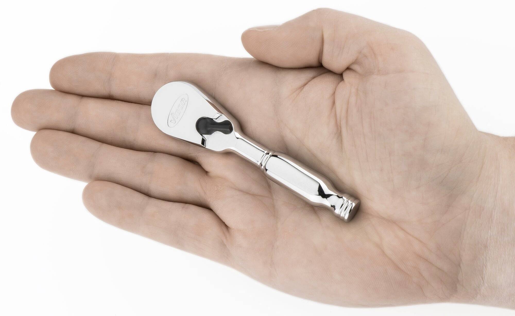 Jedna ręka trzyma srebrne narzędzie z grzechotką.