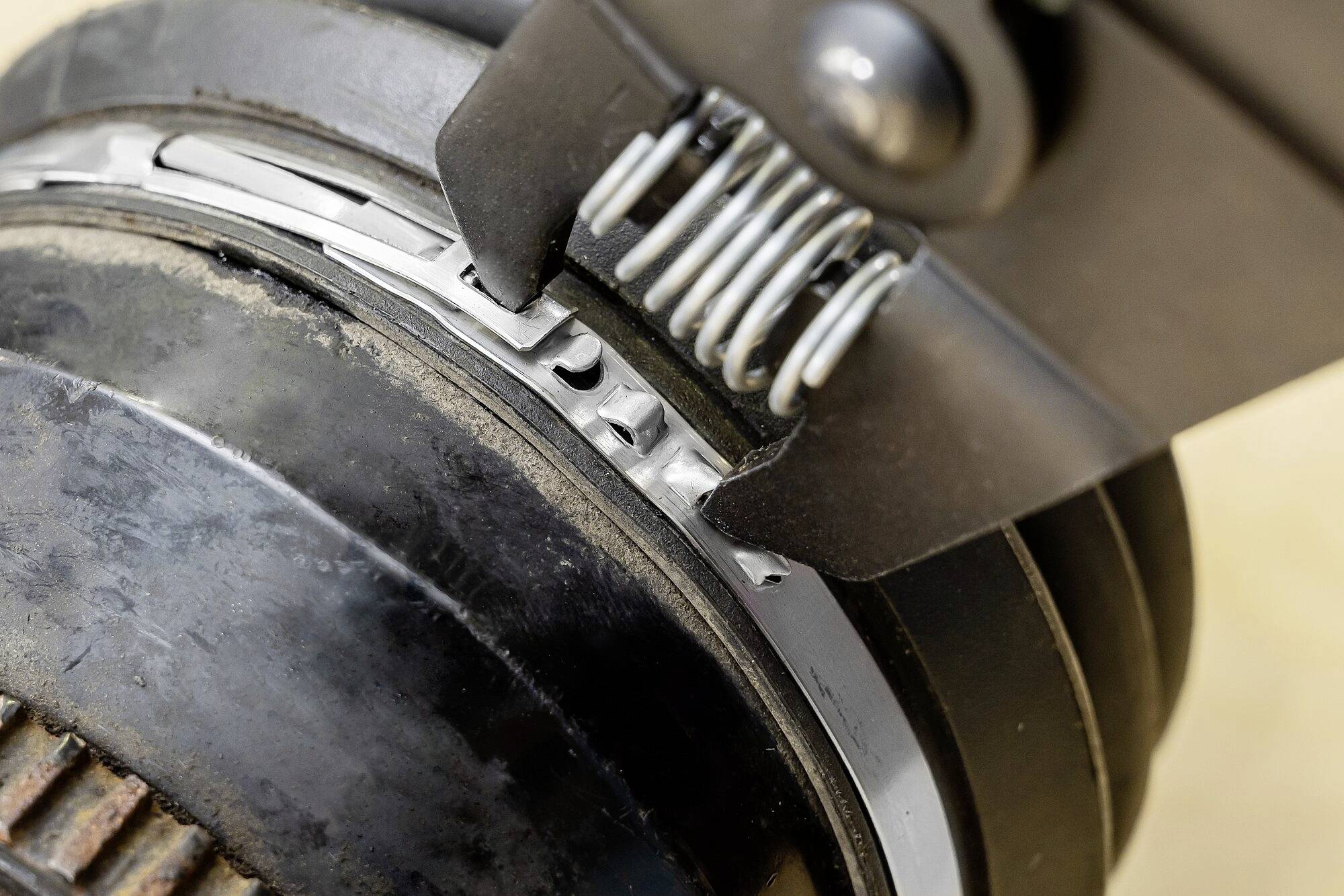 Zbliżenie mechanizmu metalowego koła zębatego z sprężynami i zębatkami, prezentujące przemysłowe komponenty, prawdopodobnie części maszyny.