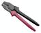 Szczypce zaciskowe z czarną i czerwoną rączką, używane do zaciskania kabli lub wtyczek. Posiada kilka różnych rozmiarów zacisków na szczęce.