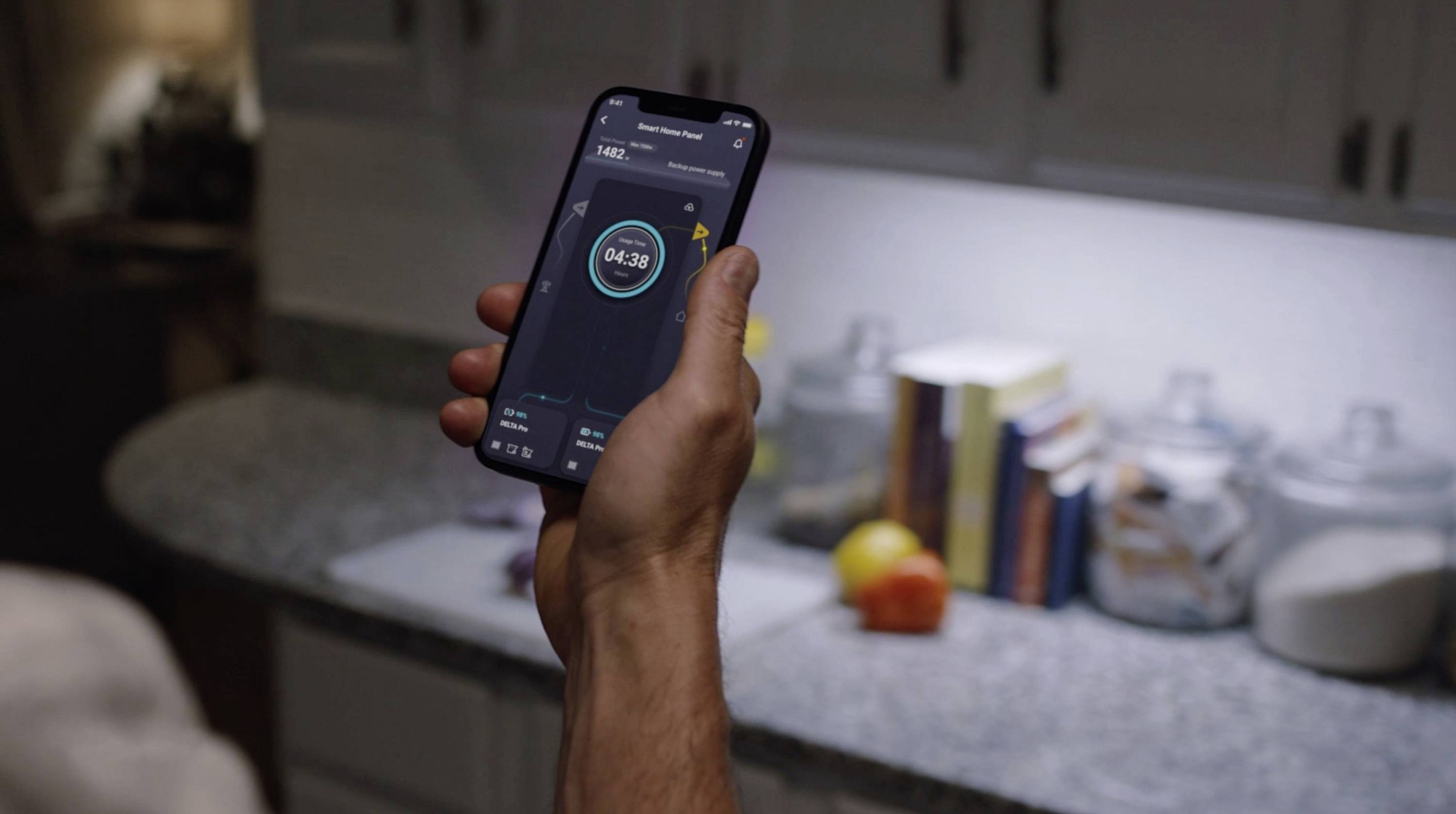 Jedna ręka trzyma smartfon wyświetlający aplikację z timerem. W tle widoczny jest blat kuchenny oraz różne przybory kuchenne.