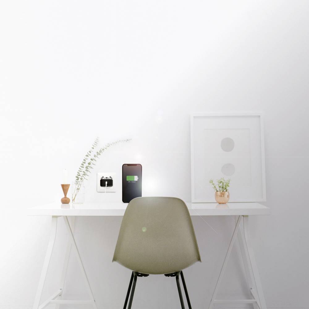 Minimalistyczne biurko z zielonym krzesłem. Na blacie leży smartfon, stoją wazony i stoi ramka na zdjęcie. Jasna, nowoczesna atmosfera.