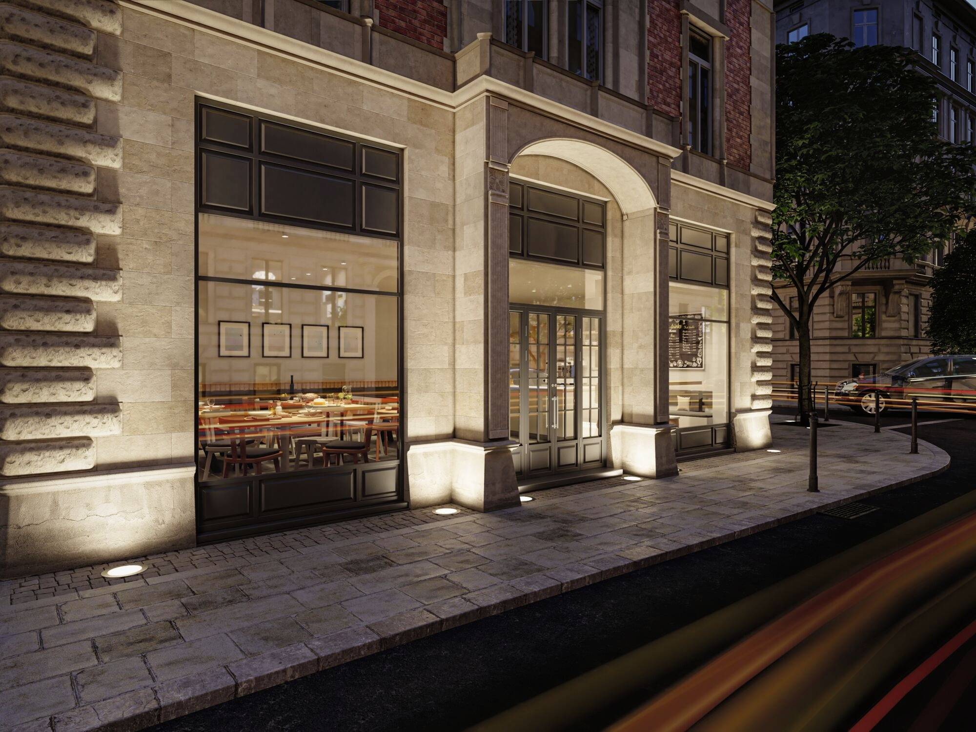 Elegancka restauracja z podświetloną fasadą nocą. Duże okna ukazują zapraszające stoły wewnątrz. Miejskie otoczenie.