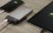Smartfon, powerbank i tablet leżą obok siebie na stole. Smartfon i tablet są ładowane.