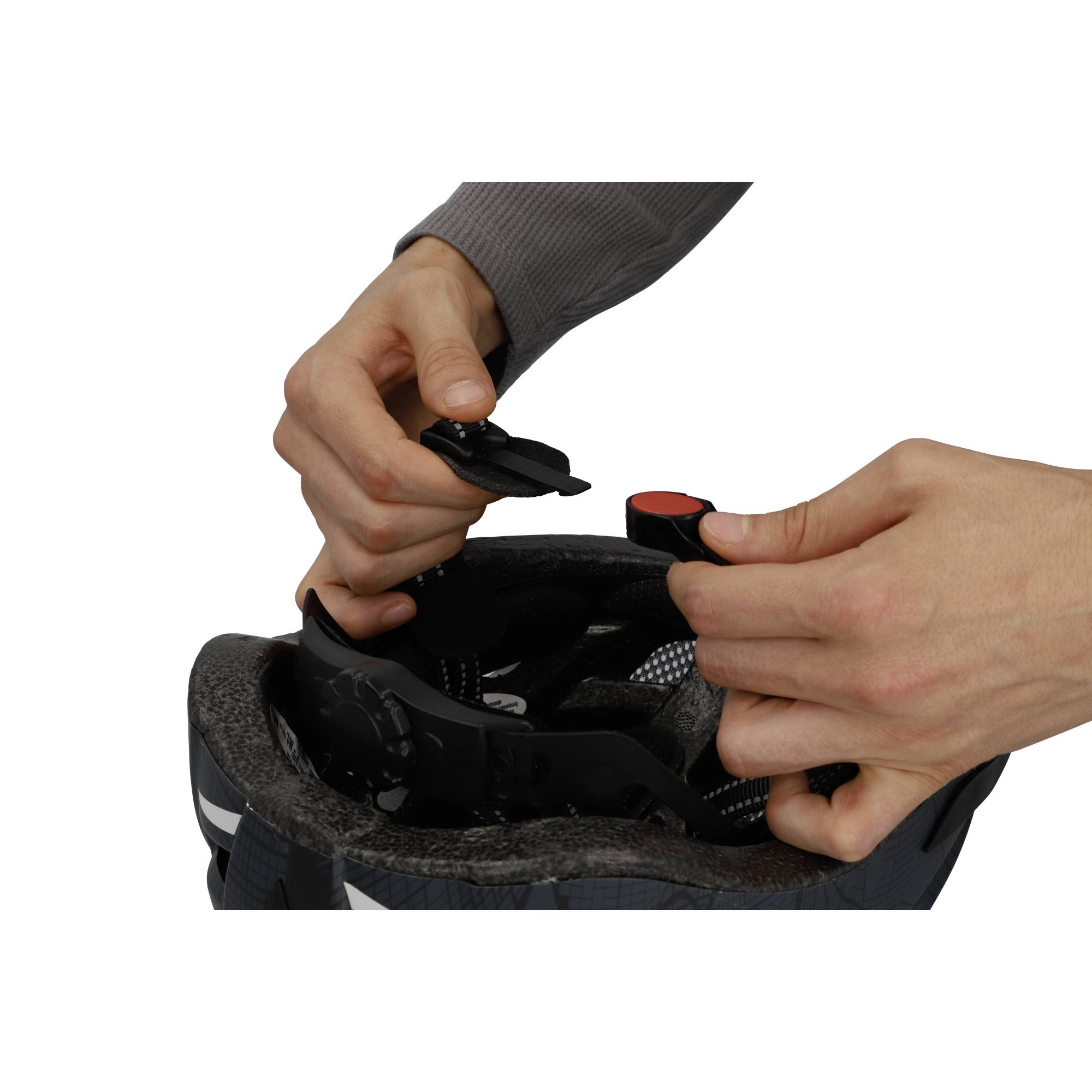 Osoba reguluje pasek kasku rowerowego. Ręce trzymają zapięcie, aby dostosować rozmiar i dopasowanie.