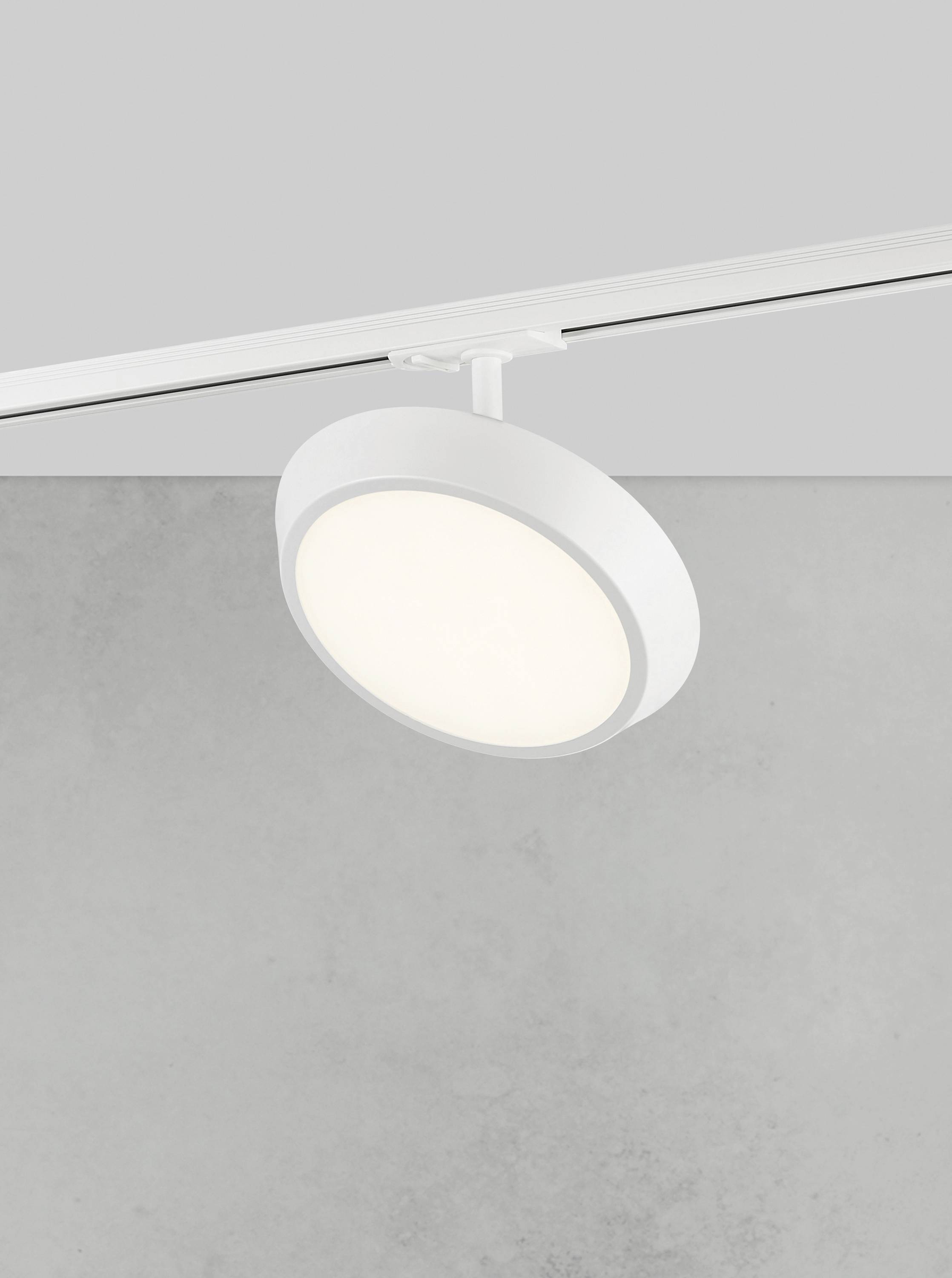 Pojedynczy biały plafon o nowoczesnym, okrągłym kształcie na szarym tle. Lampa emituje miękkie, równomierne światło.