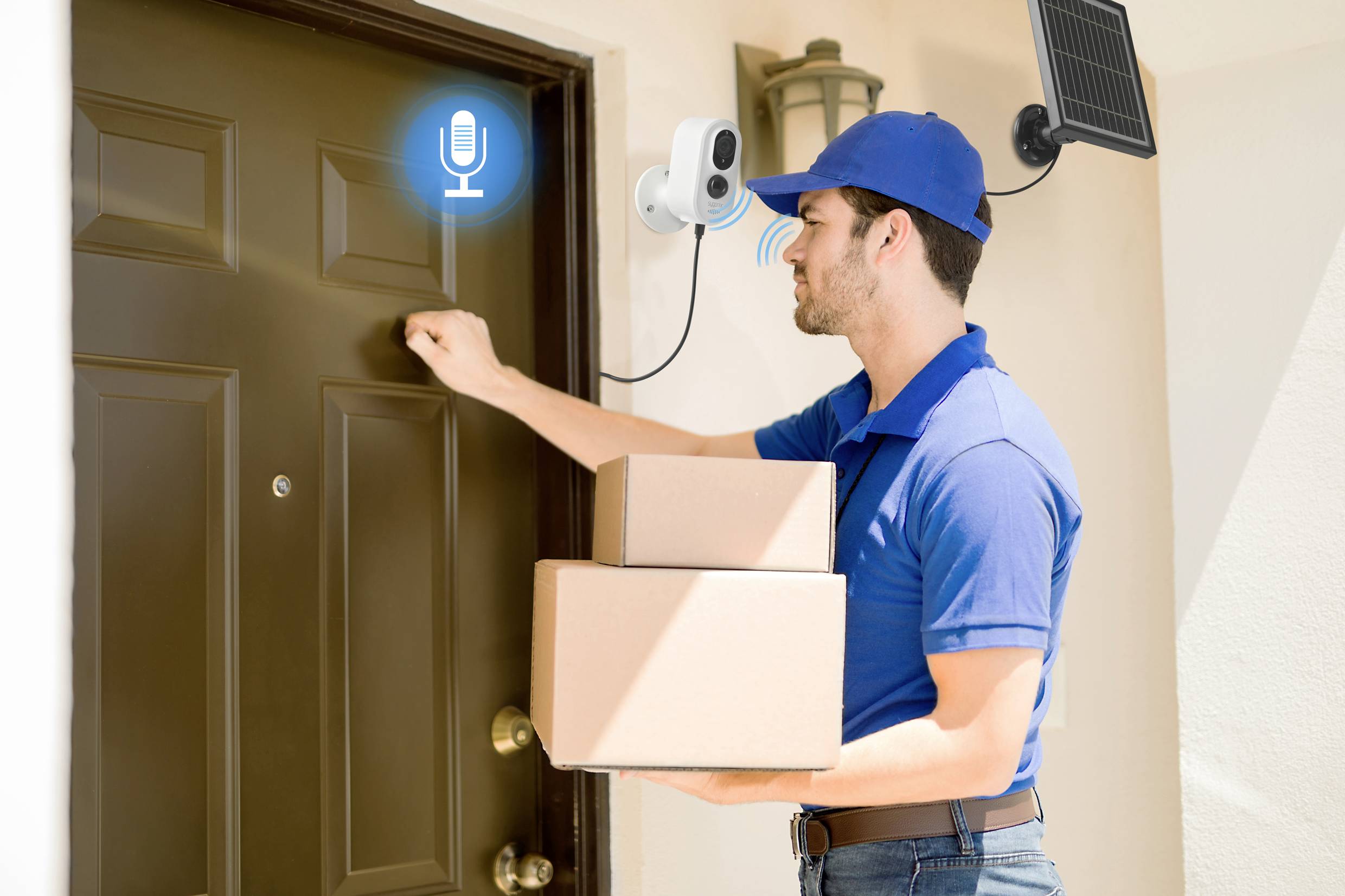 Dostawca w niebieskim mundurze puka do drzwi i trzyma dwa paczki. Kamera monitoringu z mikrofonem jest zamontowana na górze.
