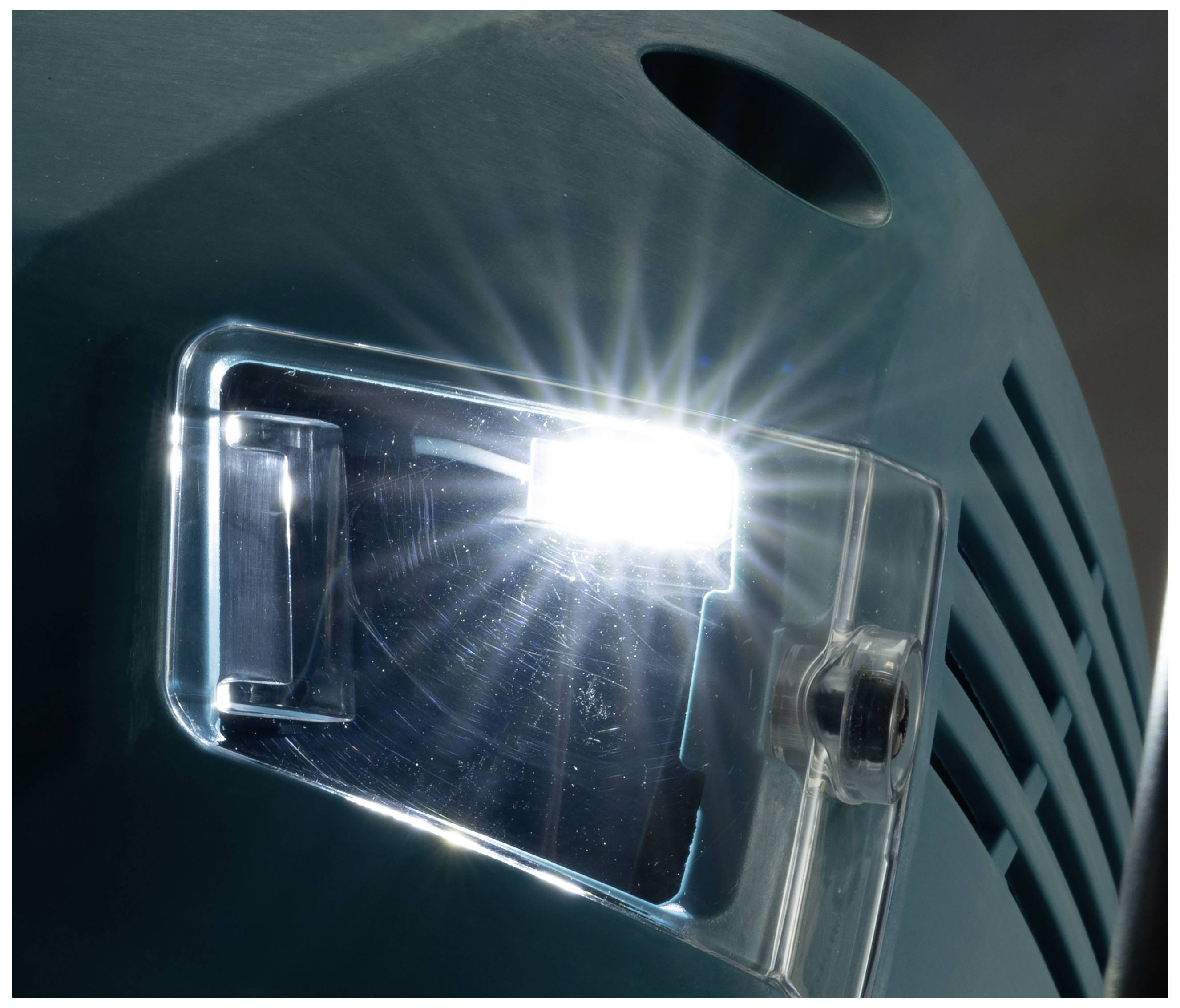 Jasna lampa LED na urządzeniu przemysłowym świeci. Widoczna plastikowa osłona i część obudowy.