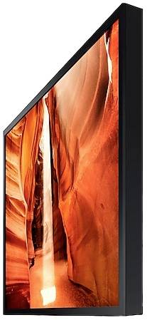 Krzywy telewizor wyświetla obraz wąskiego kanionu o czerwonych skałach, zalianego słonecznym światłem.