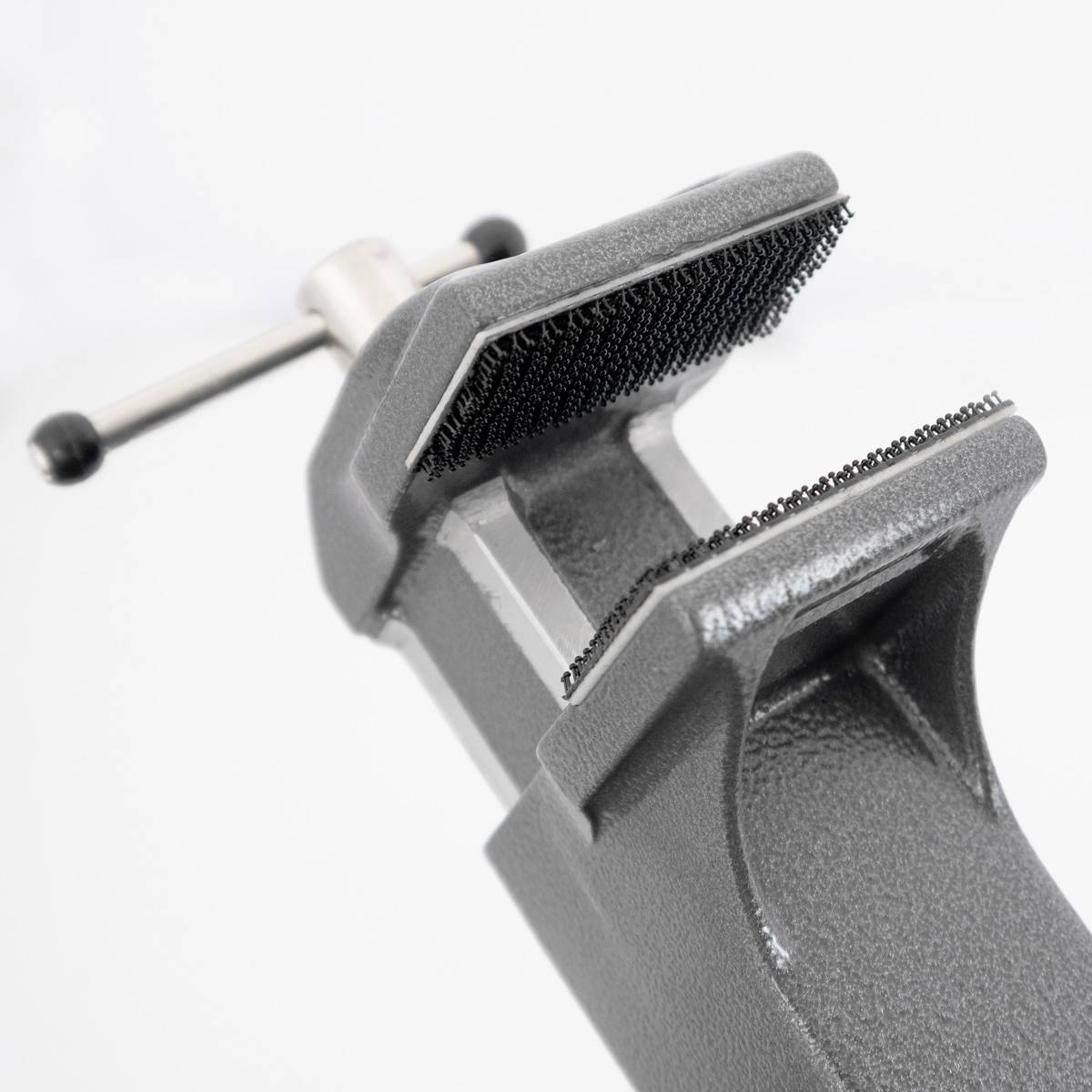 Szary imadło ze szczękami w pozycji otwartej prezentuje wkładkę przeciwpoślizgową. Uchwyt jest odpowiedni do regulacji naprężenia.