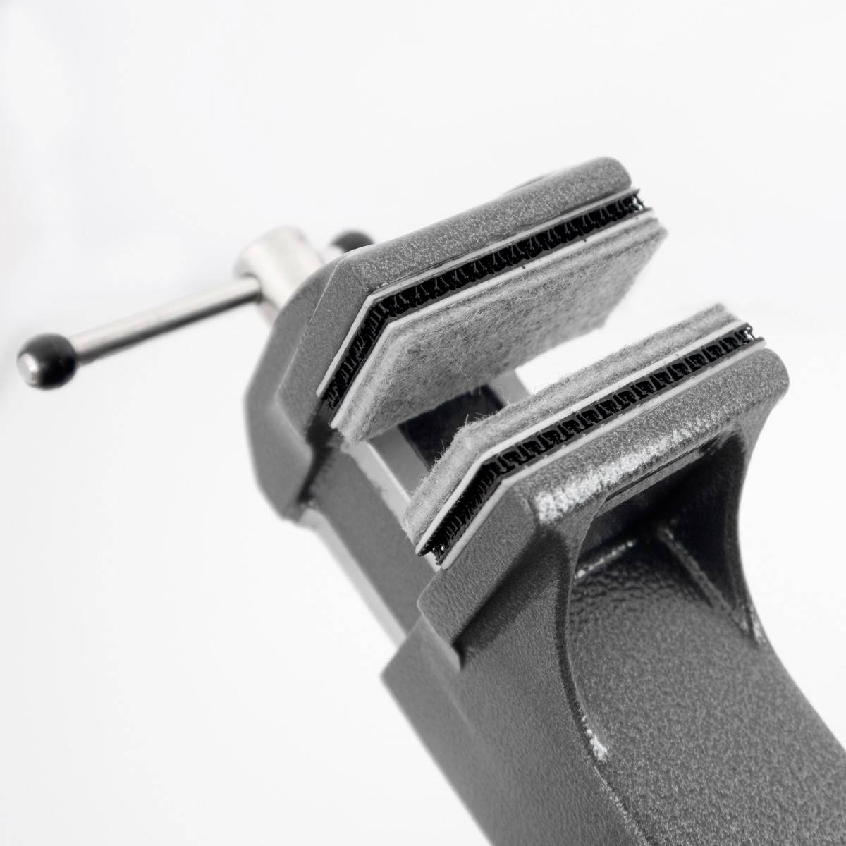 Imadło z rozchylonymi szczękami, gotowe do zaciśnięcia obiektu. Jasnoszare tło.