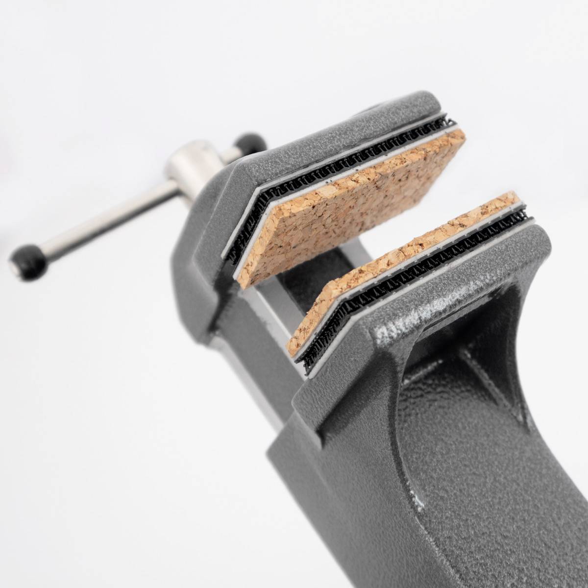 Imadło ściska kawałek korka. Uchwyt jest widoczny po lewej stronie. Fokus spoczywa na szczękach zacisku.