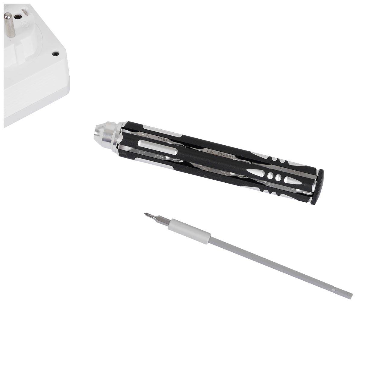 Śrubokręt z wymiennym grotem leży obok części gniazda elektrycznego.