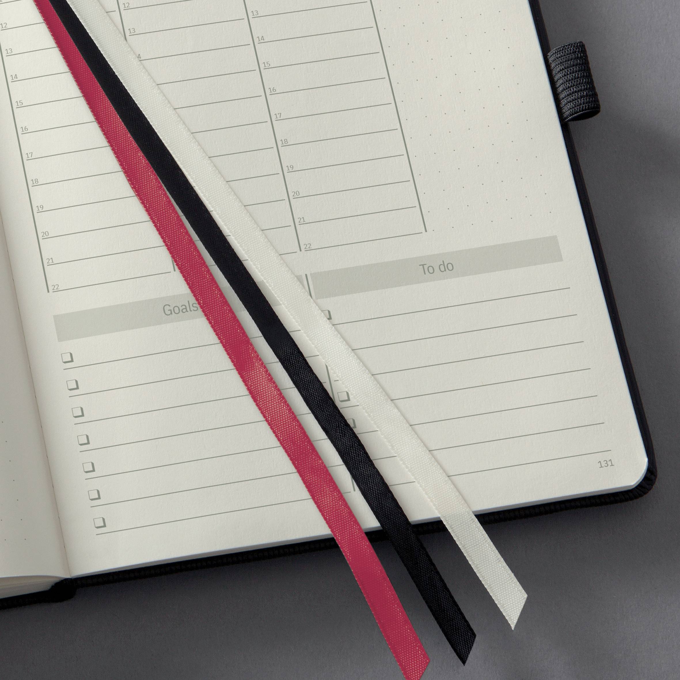 Otwarty notes z kartkami w kropki i linie. Widoczne są trzy zakładki w różnych kolorach.