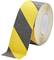 Rolka żółto-czarnej, antypoślizgowej taśmy klejącej.