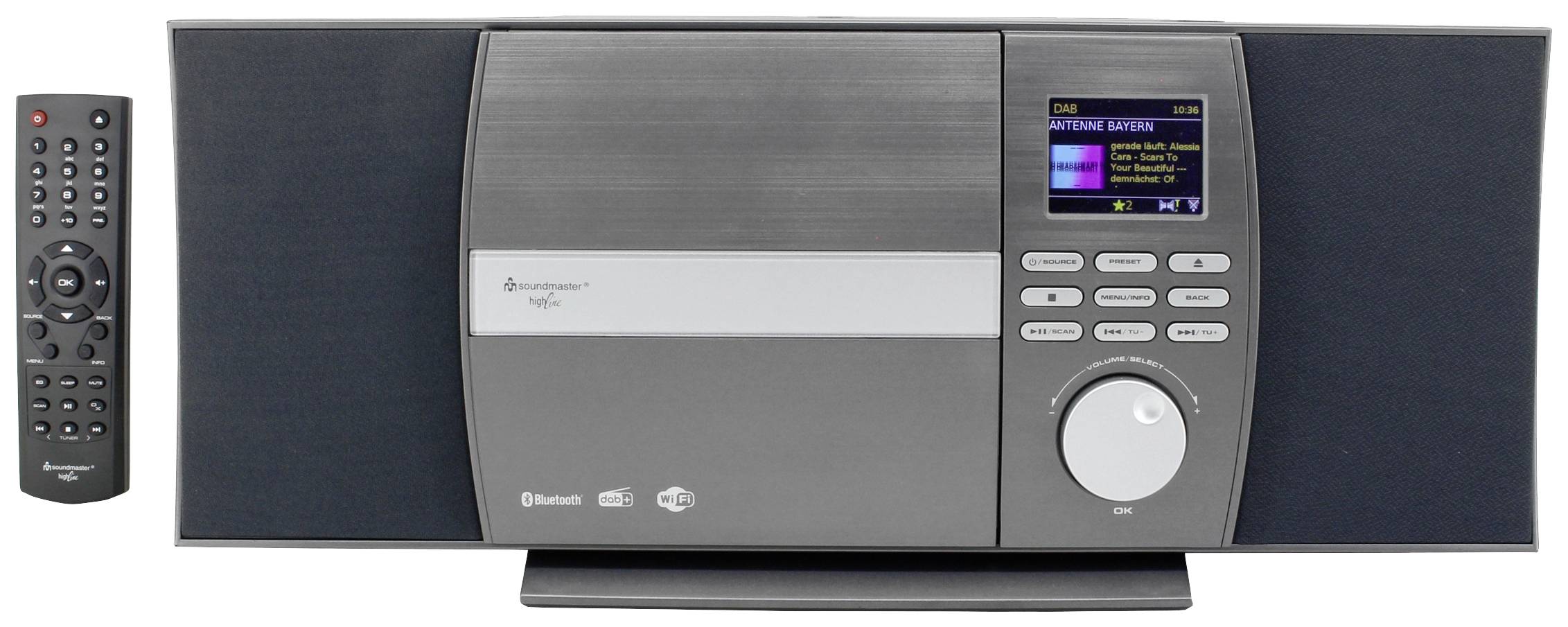 Nowoczesny system muzyczny z głośnikami i kolorowym wyświetlaczem pośrodku. Po prawej stronie obok niego leży pilot zdalnego sterowania.