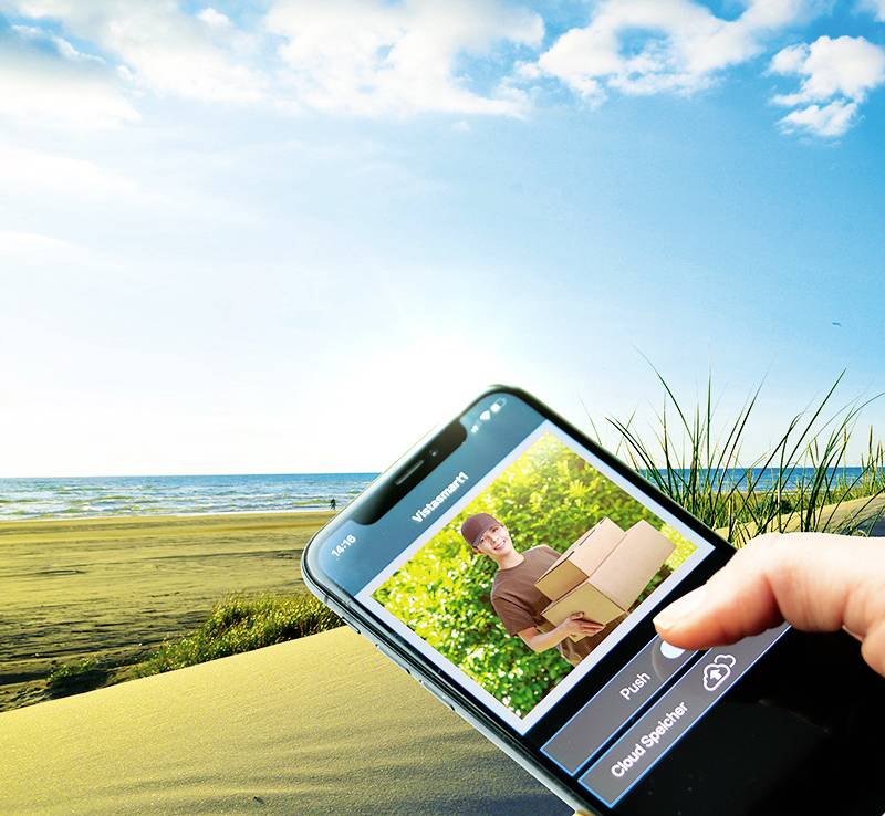 Zbliżenie smartfona wyświetlającego ekran zamówienia. W tle słoneczna plaża z błękitnym niebem i trawą.