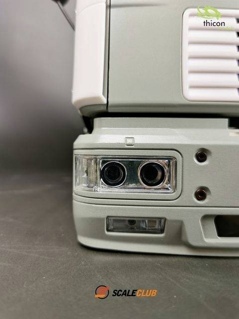 Zbliżenie przedniej części modelu ciężarówki z reflektorami i logo marki Scale Club.