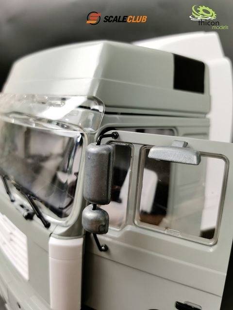 Zbliżenie modelu ciężarówki z otwartą kabiną kierowcy. Logotypy ScaleClub i Thicon Models w prawym górnym rogu obrazu.