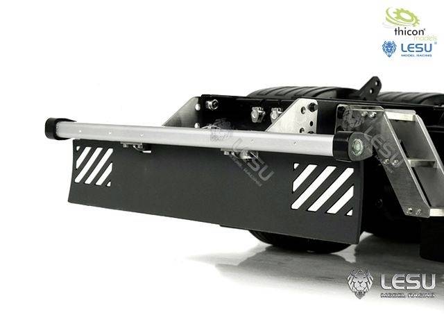 Zbliżenie szarego zderzaka z srebrną rurą i zamontowaną metalową kratką. Logotypy marki znajdują się w górnym prawym rogu.