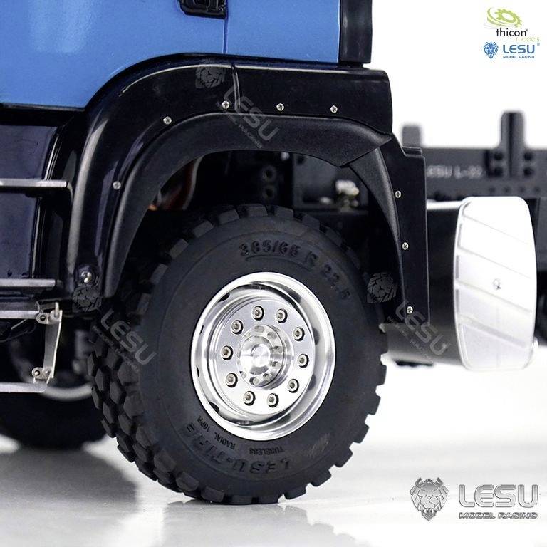 Zbliżenie niebieskiej ciężarówki modelowej z widocznym kołem i logo Lesu. Szczegółowe przedstawienie konstrukcji koła.